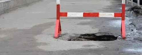 pothole with terminus barricade over it