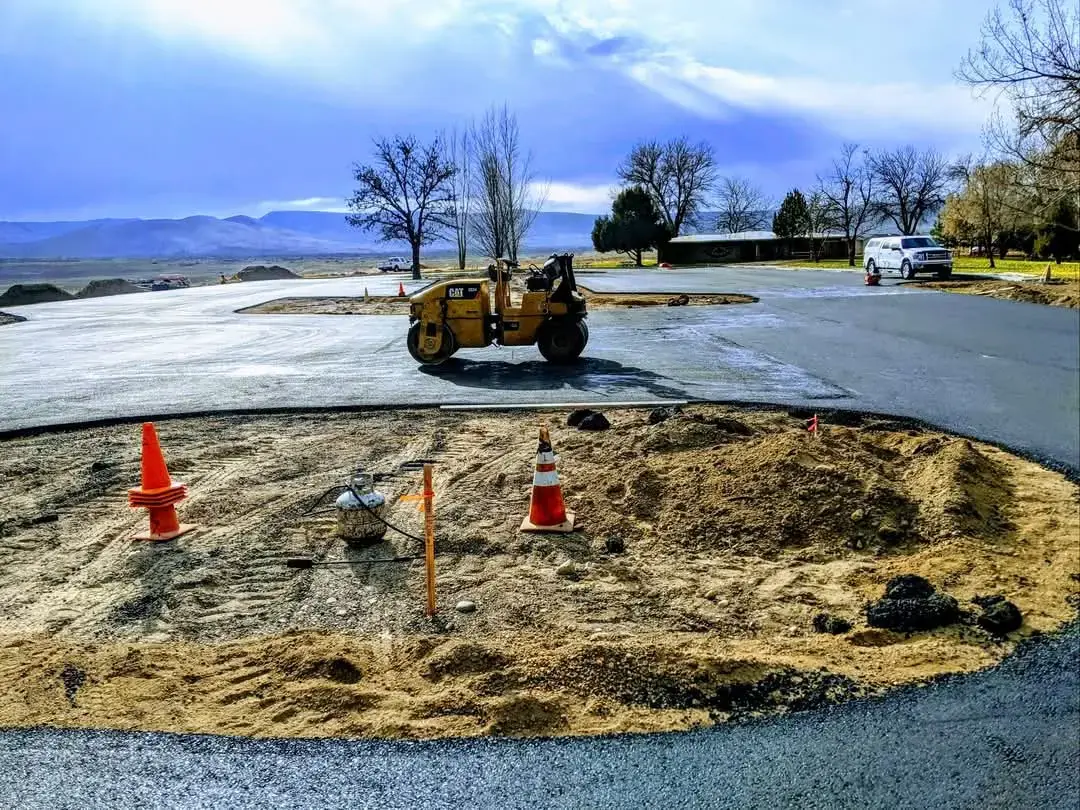 Roller on a freshly paved road with mountains in the background.